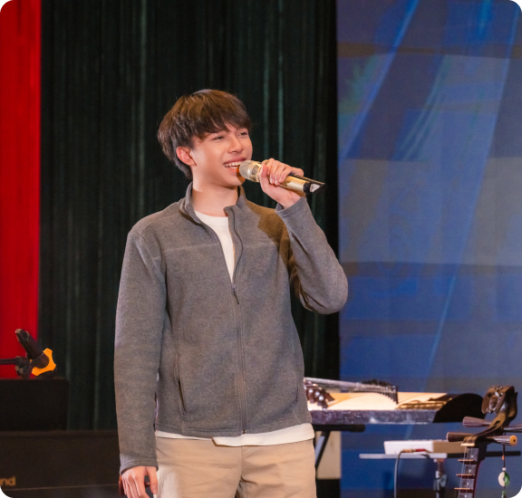 Khoi performing on stage with a microphone